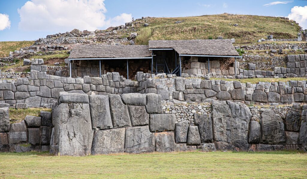 Ancient Inca stone walls and shelter on hillside showcasing architectural prowess.