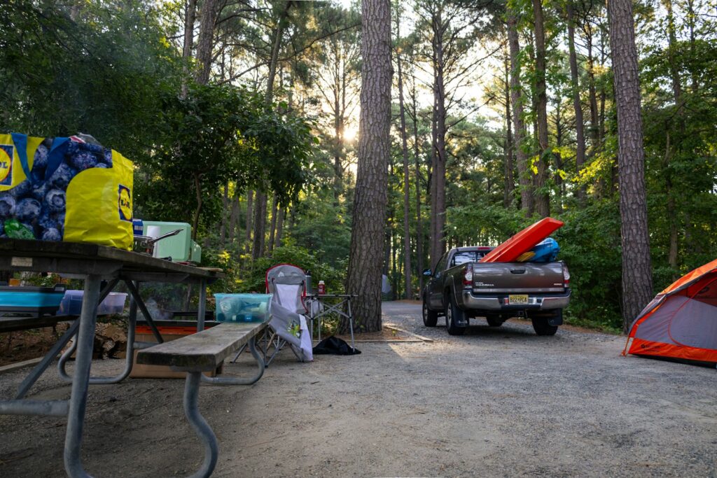 A truck parked next to a tent in the woods