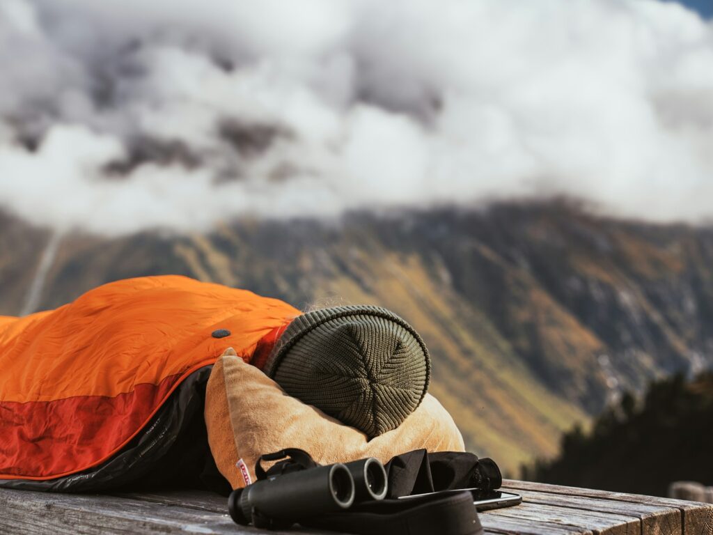 A man sleeping on top of a wooden bench