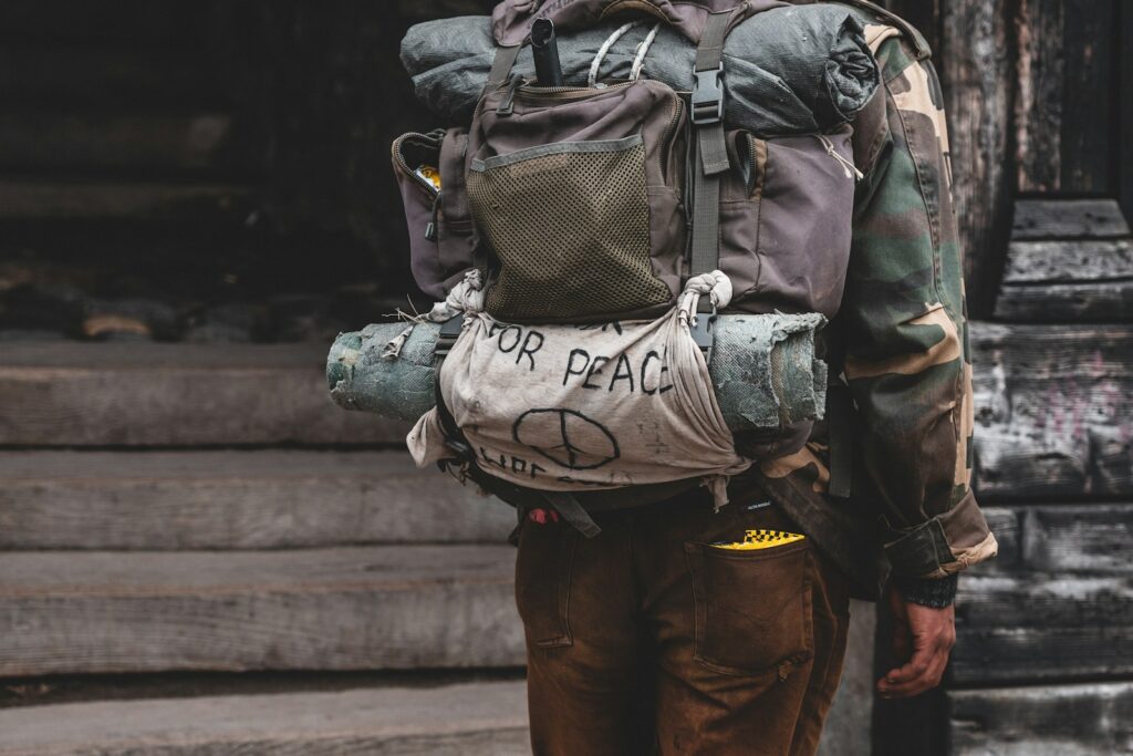 a man with a back pack walking down a street