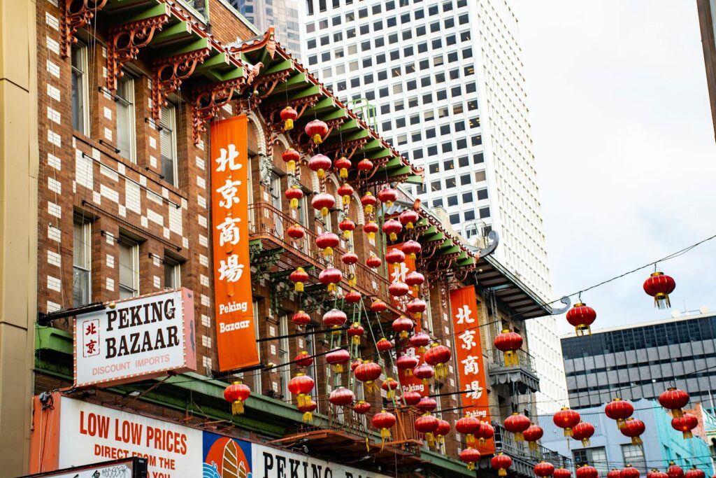 Colorful Chinese lanterns adorn the Peking Bazaar in Chinatown, creating a vibrant street scene.