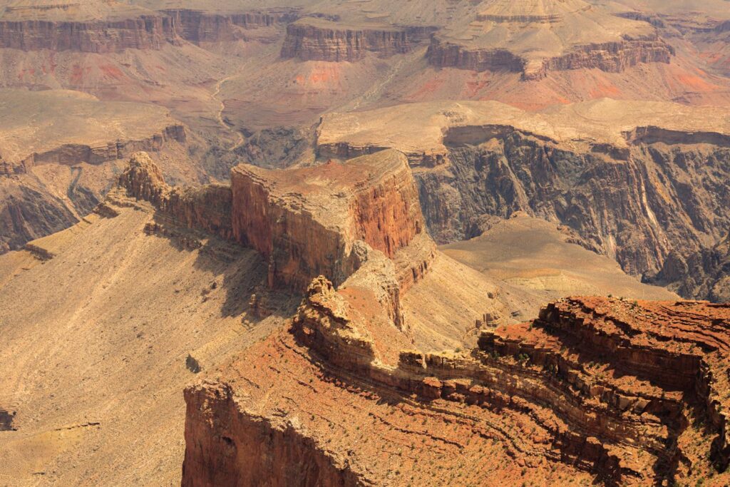 Stunning aerial view of the Grand Canyon's rugged terrain showcasing dramatic cliffs and layers of rock formations.
