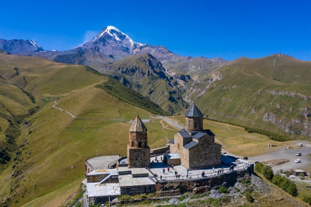 A stunning aerial view of Gergeti Trinity Church against the backdrop of Mount Kazbek in Georgia.