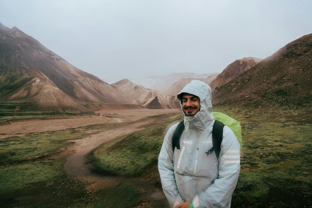 Man in raincoat exploring the rugged Icelandic highlands.