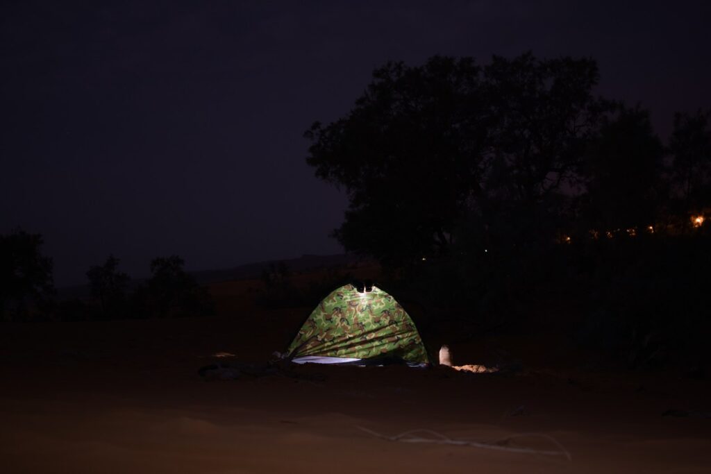 a tent with a fire in the middle at night