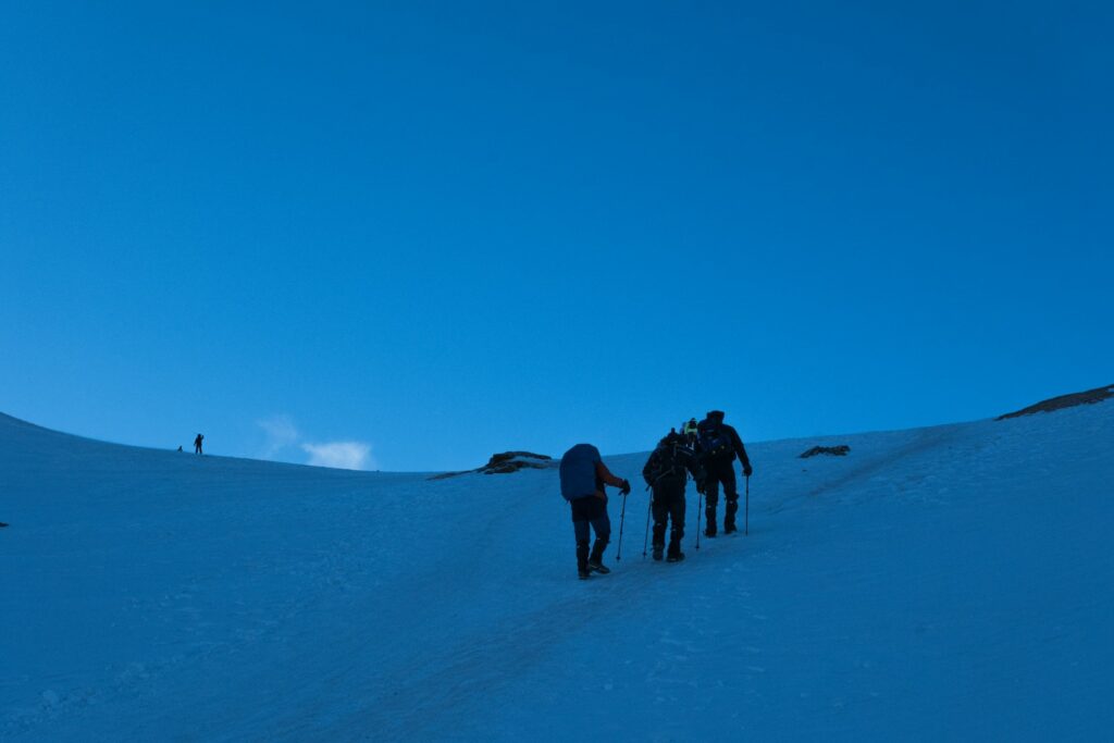 A group of people walking up a snow covered slope