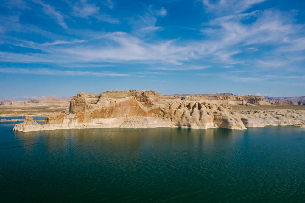Aerial view of Lake Powell with striking rock formations under a clear blue sky.