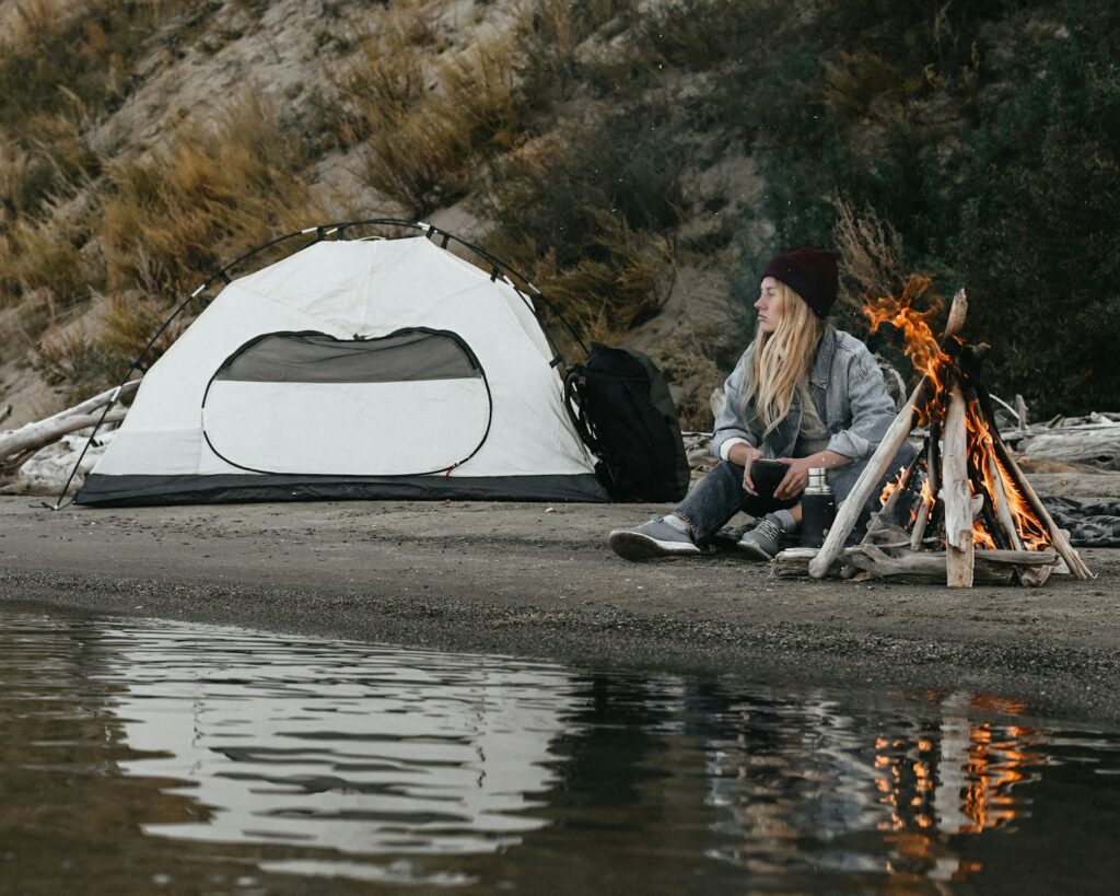 a man sitting next to a campfire