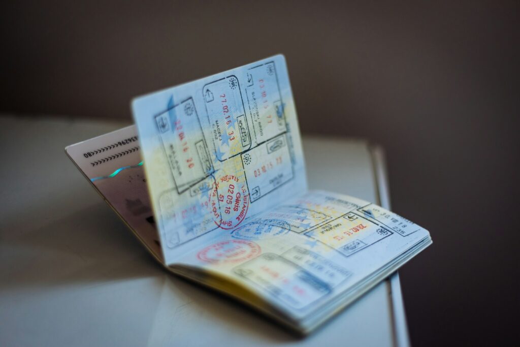 A close-up of an open passport displaying various stamps and visa pages, showcasing travel history and authentication marks.