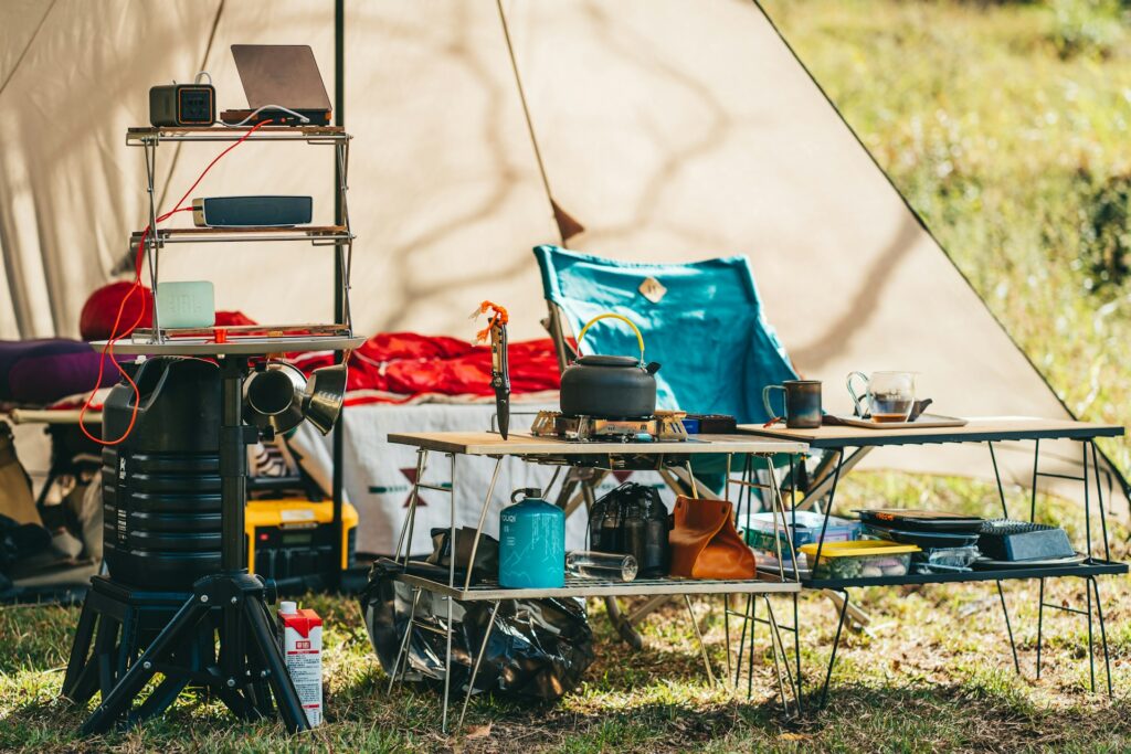 A tent with a table and chairs arranged on green grass, creating a cozy outdoor gathering space.
