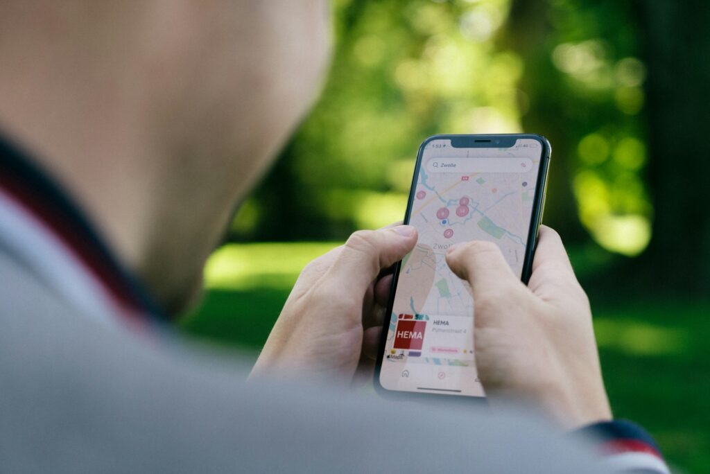 A person uses a smartphone to navigate a map of Zwolle, focusing on various locations marked with red dots.