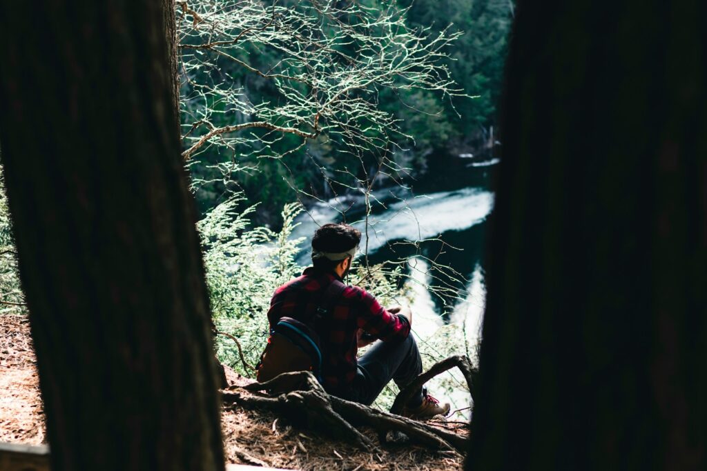 A man sitting on a log in the woods