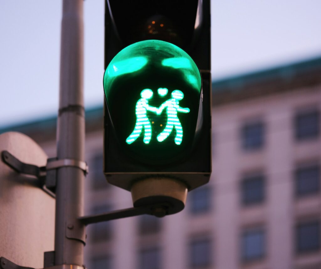 A green pedestrian traffic light depicting two stick figures holding hands, symbolizing love and friendship.