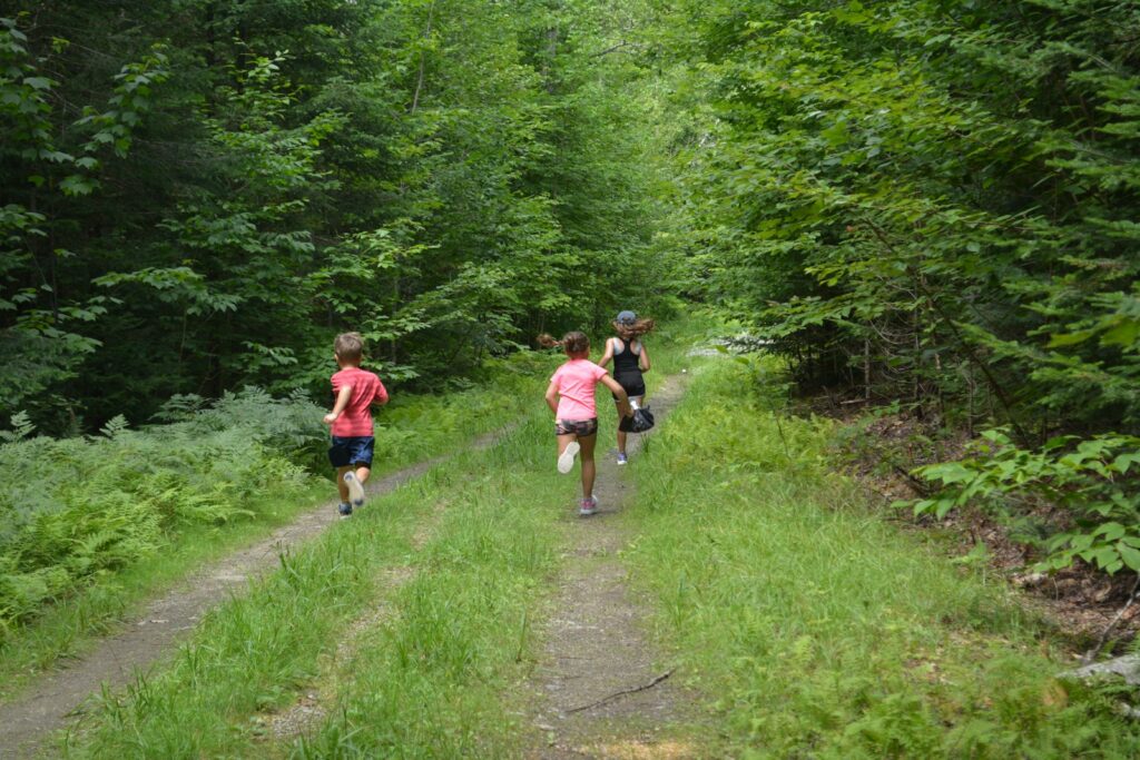 A couple of people running down a dirt road