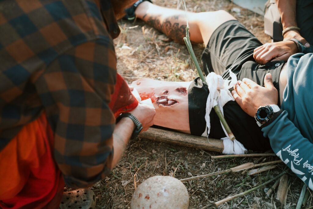 A group of men standing around a man laying on the ground.