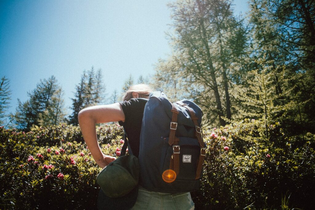 woman carrying bucket backpack facing backward