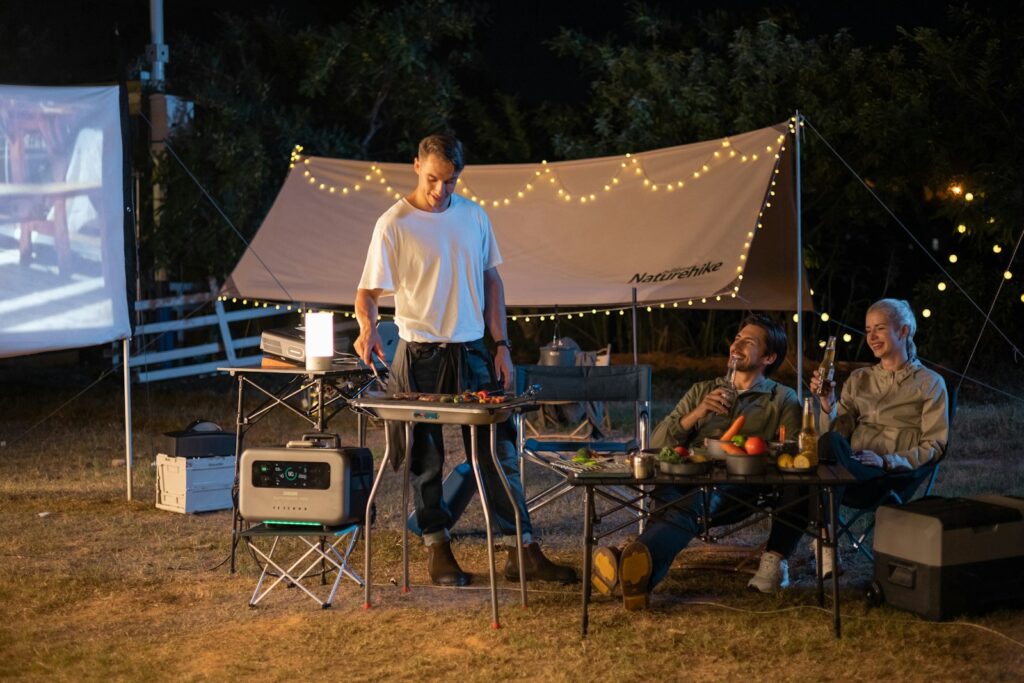 a group of people sitting around a table in a field