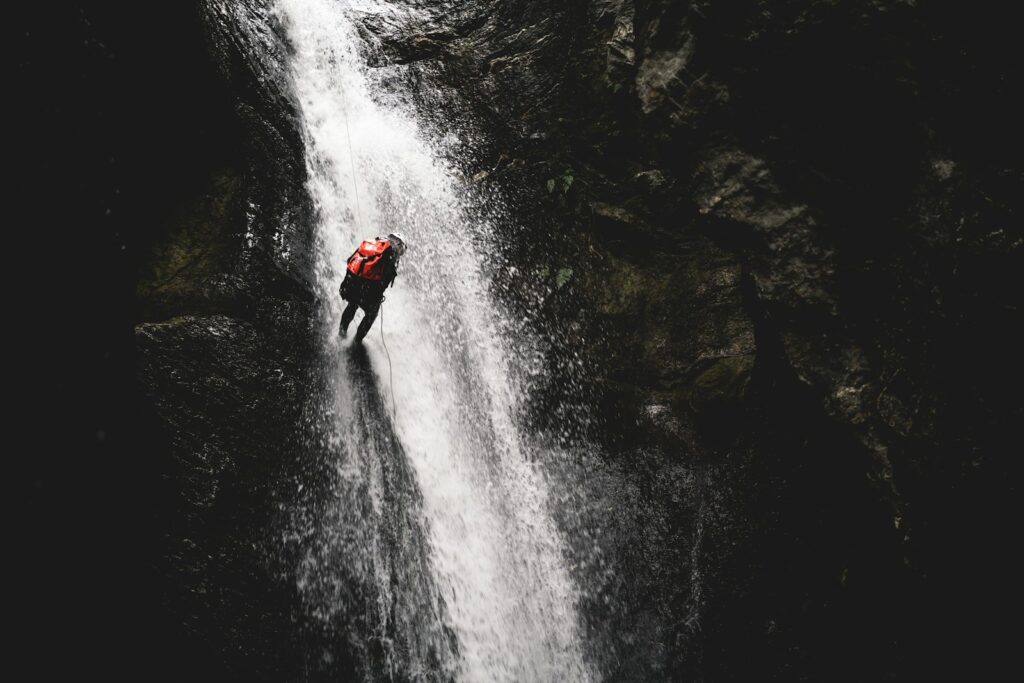 A man climbing up a waterfall in the mountains