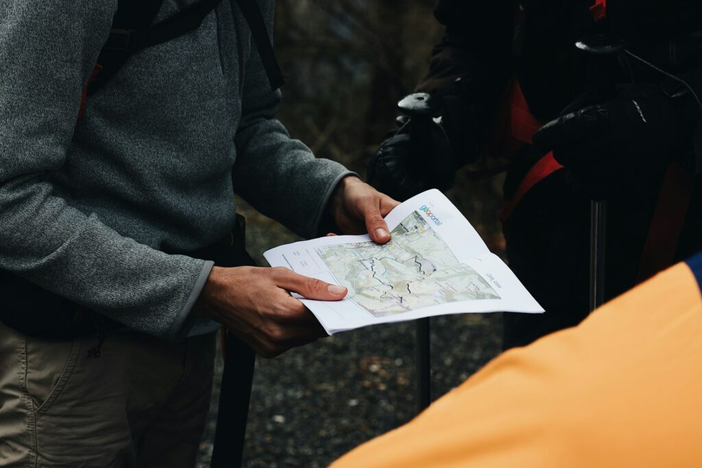 A man studying a map intently while holding it in his hands outdoors.