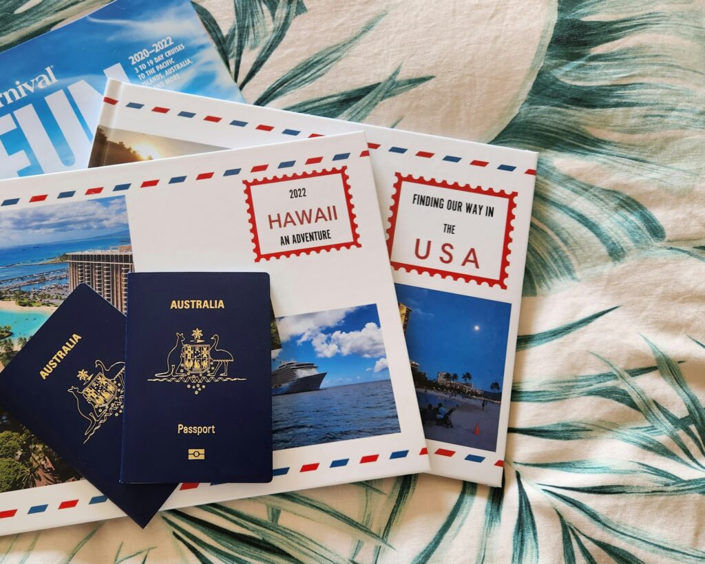 Two Australian passports on a tropical-themed background, surrounded by travel brochures for Hawaii and the USA adventure.