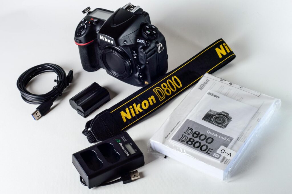 Nikon D7000 DSLR camera displayed with various accessories, including lenses and a camera bag.