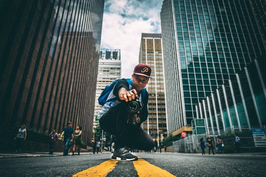 A man wearing a hat and jacket jumps on a skateboard, showcasing his skills in an urban setting.