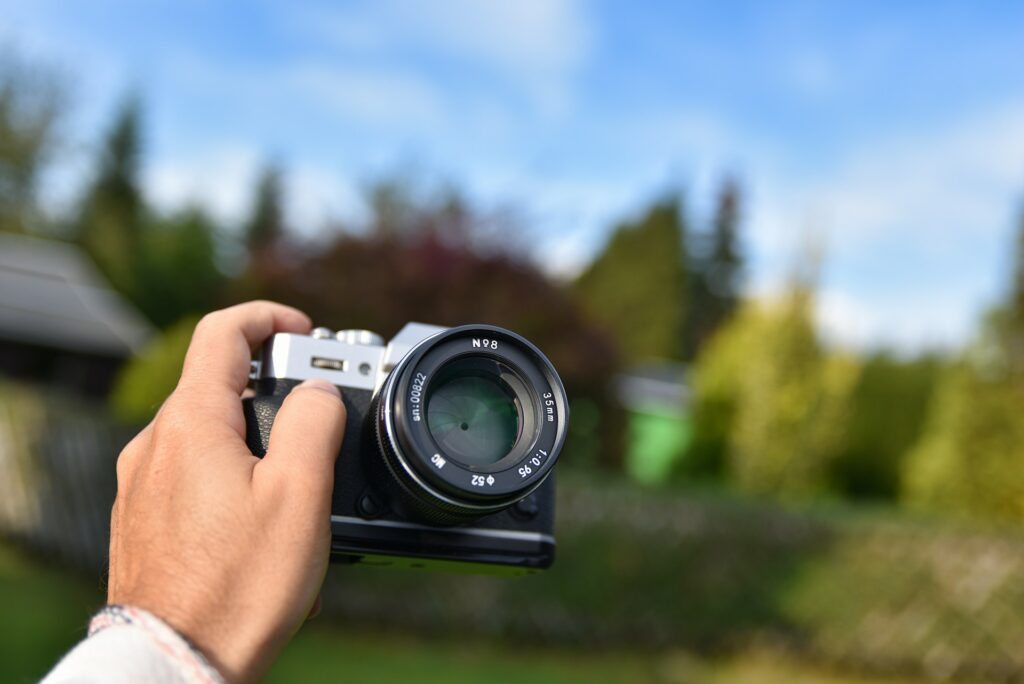 Person holding black and silver camera photo.