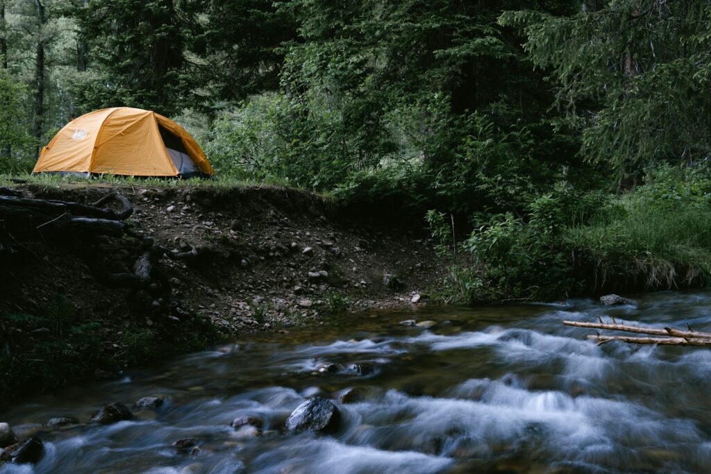 a tent on a rocky river