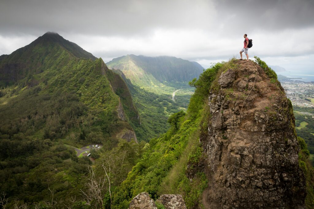 Man on top of the mountain during daytime.