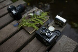 A camera and lens resting on a book atop a wooden bench, showcasing a blend of photography and literature.